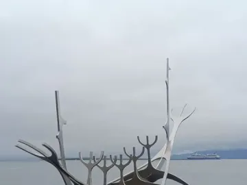 The Sun Voyager sculpture stands beside the water with a cruise ship in the background.