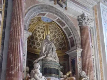 Tomb of Pope Alexander VII with a praying figure, white marble allegorical statues, and a dramatic draped canopy above a doorway.