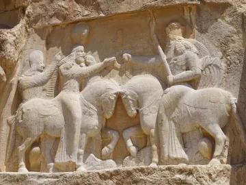 Ardashir Investiture Relief showing two mounted figures facing each other with smaller figures behind them and forms beneath the horses.