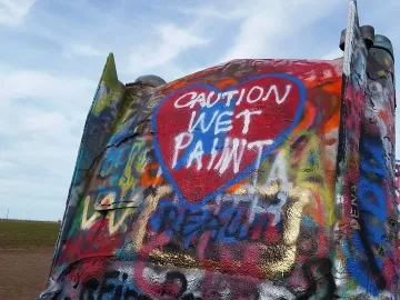 Graffitied Cadillac Ranch car tailfin with a red heart reading \