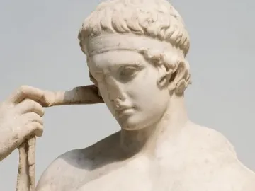 Farnese Diadumenos marble sculpture shown in close-up, with the athletic figure adjusting a band around his head