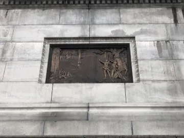 Bronze relief panel on the Trenton Battle Monument showing a scene with several figures around a tree.