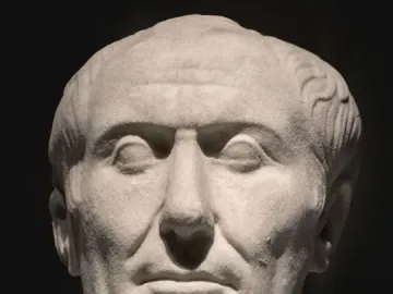 Weathered marble bust of the Tusculum portrait showing a stern-faced man with receding wavy hair and deep facial wrinkles.