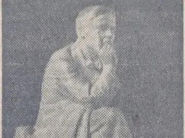 Chekhov Monument showing a bearded man seated on a bench, resting his chin on his hand.