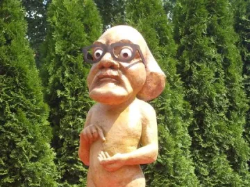 Citizen Włapko sculpture of a nude figure with an oversized head, glasses, and a bomb at its feet.