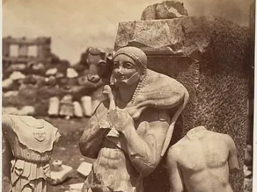 Weathered marble Kritios Boy torso among ancient stone fragments