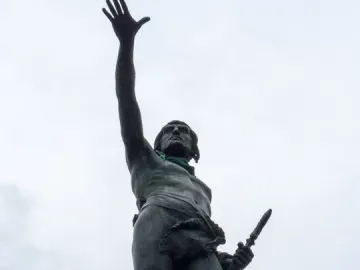 Monument to Viriato showing a barefoot warrior statue on a stone base, raising one hand and holding a dagger.