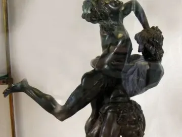Hercules and Antaeus bronze sculpture showing two muscular figures in a struggle on a marble pedestal.