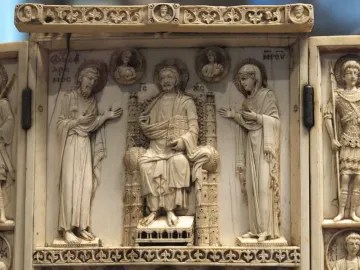 Harbaville Triptych ivory carving with a central seated figure flanked by haloed figures and hinged side panels with standing attendants.