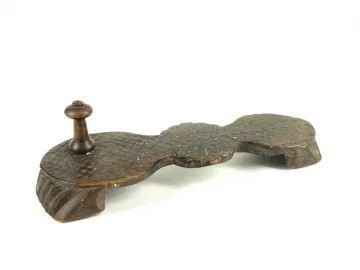 Paduka wooden sandal with a curved base and carved feet support.