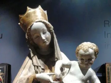Beautiful Madonna of Wrocław holding a nude child on her left hip and offering a small round object.