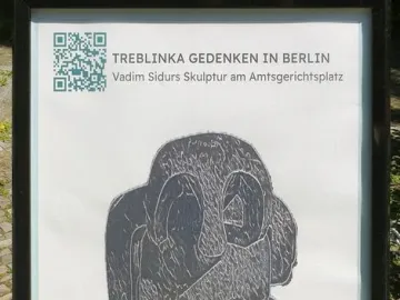 Framed Treblinka Gedenken sign with a dark abstract sculpture image and QR code