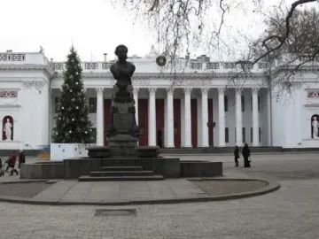 Pushkin bust on a tall ornate pedestal in a paved plaza