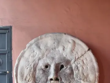 Bocca della Verità stone mask with a bearded face and open mouth on a pedestal