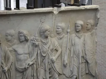 Cancelleria Reliefs showing a marble panel with male figures in a military procession, some wearing tunics and togas and others carrying shields and spears.