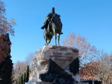 Bronze equestrian statue of General Martínez-Campos on a tiered stone pedestal reflected in a pool.