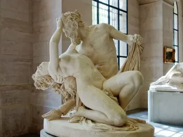 Satyre et bacchante marble sculpture showing two intertwined figures in a museum hall