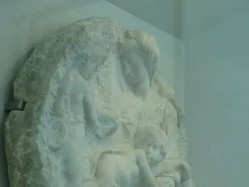 Taddei Tondo marble relief with a seated woman, an infant, and a standing youth.