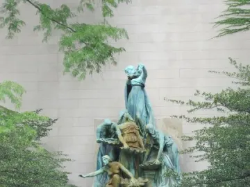 The Fountain of the Great Lakes sculpture with five female figures, water jets, and two bicycles nearby.