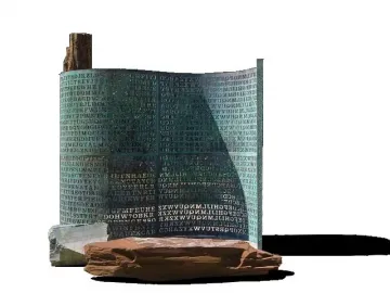 Kryptos sculpture with a curved patinated metal surface covered in etched letters and numbers, standing on rocks.