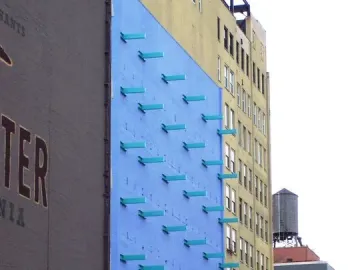 The Wall with a blue facade and turquoise rectangular protrusions arranged in diagonal rows.
