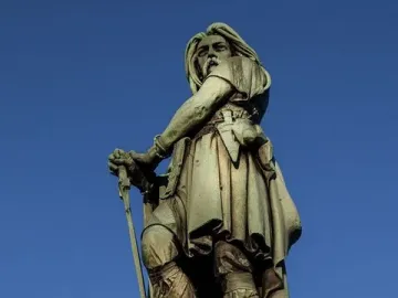 Vercingetorix Monument, a bronze warrior statue holding a sword against a blue sky