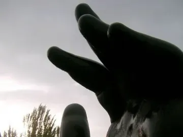 Botero’s Hand sculpture rising from a pedestal on a grassy median in Madrid
