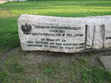 Monument of Common Martyrdom stone memorial with engraved Polish and English text and a metal eagle emblem.