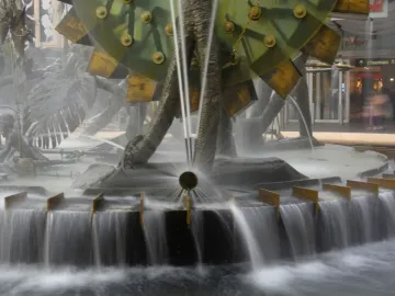 Hornsby Water Clock with central jets of water and large green wheel-like elements.