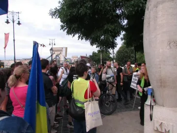 Zero Kilometre Stone partially visible with the carved letters KM and a megaphone leaning against it.