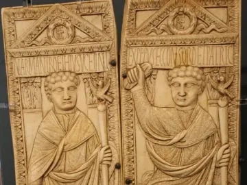 Diptych of Boethius with two carved ivory panels showing standing male figures in robes holding staffs topped with birds.