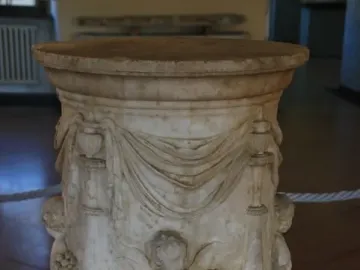 Four Seasons Altar with carved marble reliefs, draped swags, and putti holding flowers and grapes.