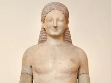 Kouros marble statue of a standing nude male figure with braided hair, an archaic smile, and a missing left forearm.