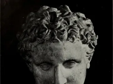 Head and upper torso of the Ludovisi Ares marble statue with curly hair and a solemn expression against a dark background.