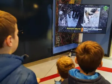 The Hand of Irulegi shown on a digital screen alongside an image of an excavation scene.
