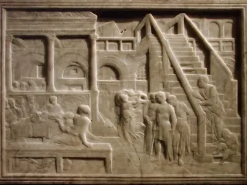 The Feast of Herod relief showing figures gathered around a table beside a dancing figure in an arched architectural setting.