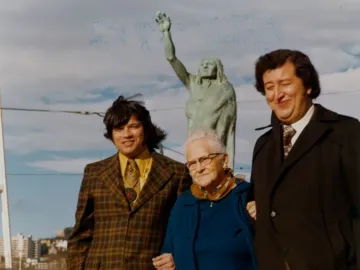 Chief Seattle statue with three people posing in front of it