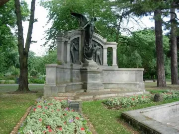 Titanic Engineers\' Memorial with a winged bronze figure holding a wreath on a ship-like stone base in a park.