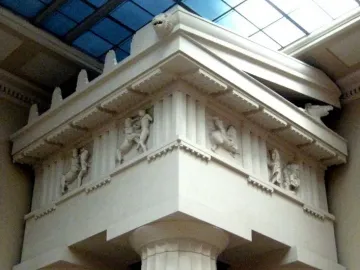 Parthenon metopes with marble relief figures in a battle scene beneath a glass ceiling.