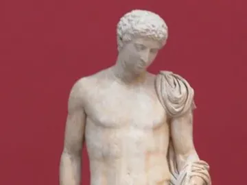 Hermes of Aegium, a light-colored marble statue of a nude male figure with a draped cloth over one shoulder and arm, standing against a dark red background.