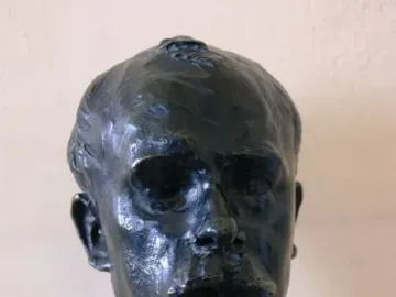 Bronze bust of Octave Mirbeau on a light marble base