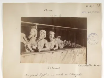 Trisomatos Typhon, a stone sculpture with three bearded male torsos joined at the waist and a long serpent-like form extending to the right.