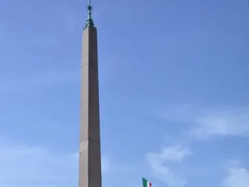 Horse Tamers statues flanking the Quirinal obelisk beneath a blue sky.