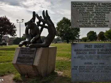 Bronze Monument to Dog Jock sculpture showing a dog nestled between two large hands on a stone pedestal in a park.
