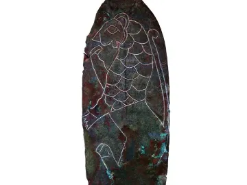 Spear of Lugal with an incised roaring cat-like figure on a corroded dark metal surface.