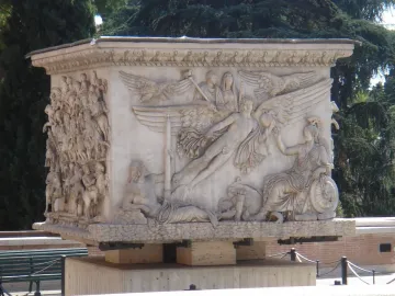 The marble base of the Antoninus Pius Column with detailed relief scenes, including a winged apotheosis panel and a procession of figures.
