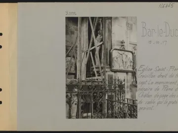 The Transi of René of Chalon skeletal stone sculpture stands behind an ornate iron fence, with wooden braces supporting it.