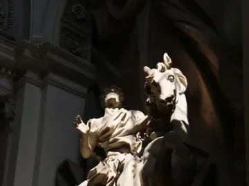 The Vision of Constantine marble statue of a man on a rearing horse, lit by a dramatic shaft of light.