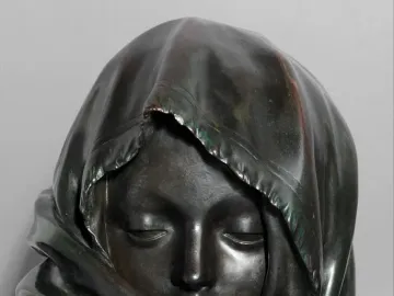 Close-up of the Winter sculpture’s head with closed eyes and a tightly draped head covering.
