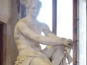 Ludovisi Ares seated with a shield beside him and a small winged figure near his leg.
